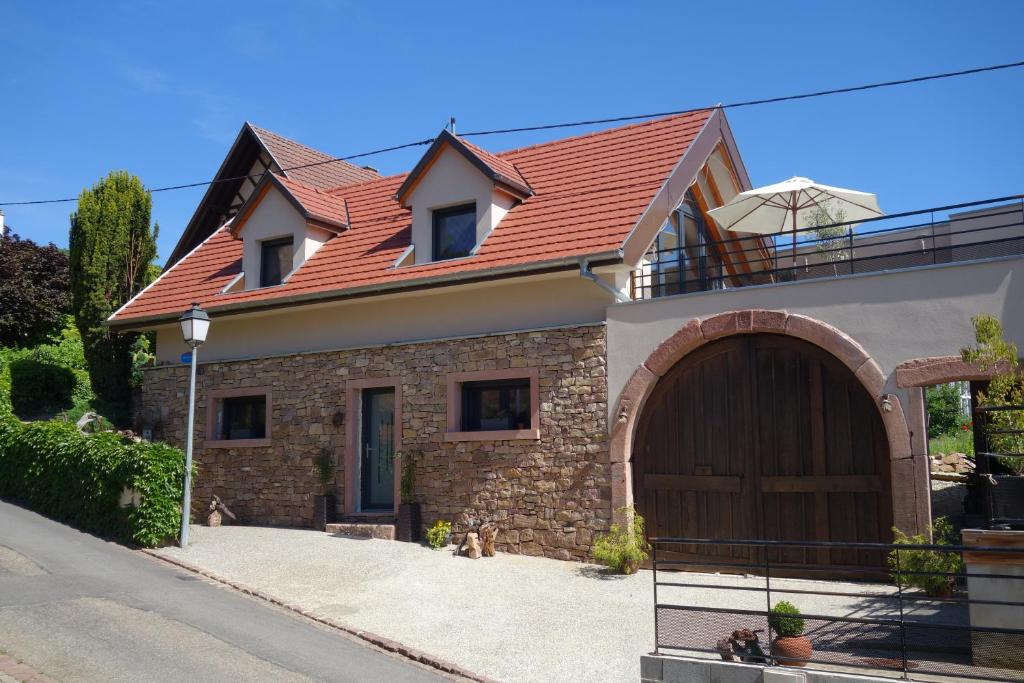 ein Haus mit einem braunen Dach und einer Garage in der Unterkunft Gite La Fixoune in Voegtlinshoffen