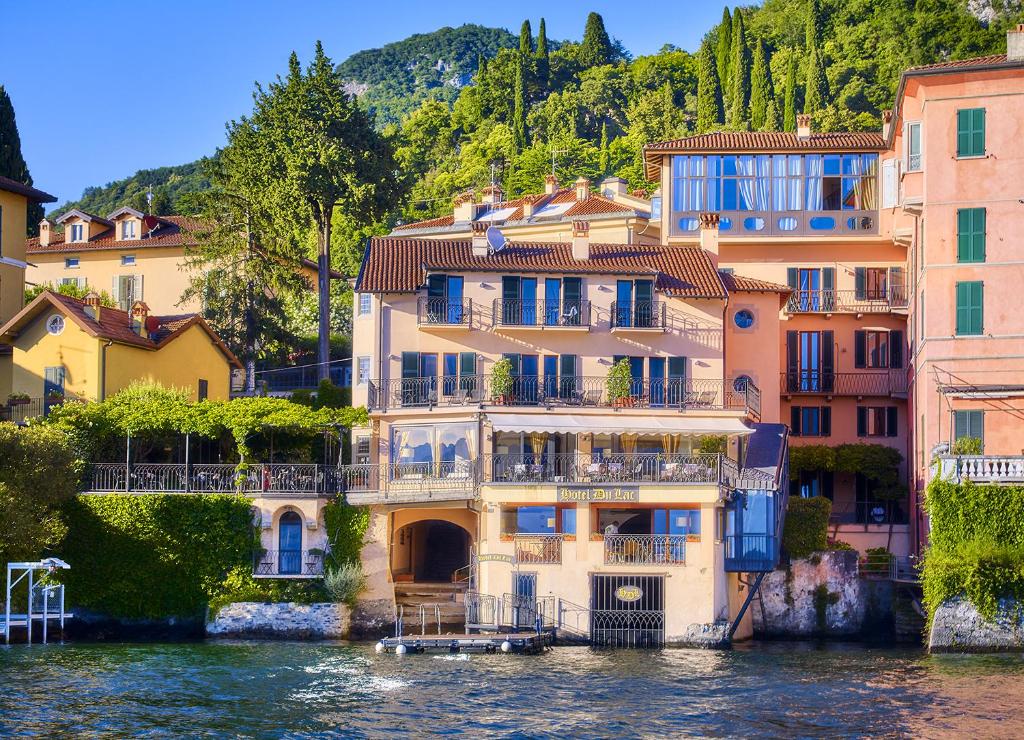 a building on the water in front of buildings at Hotel du Lac Varenna in Varenna