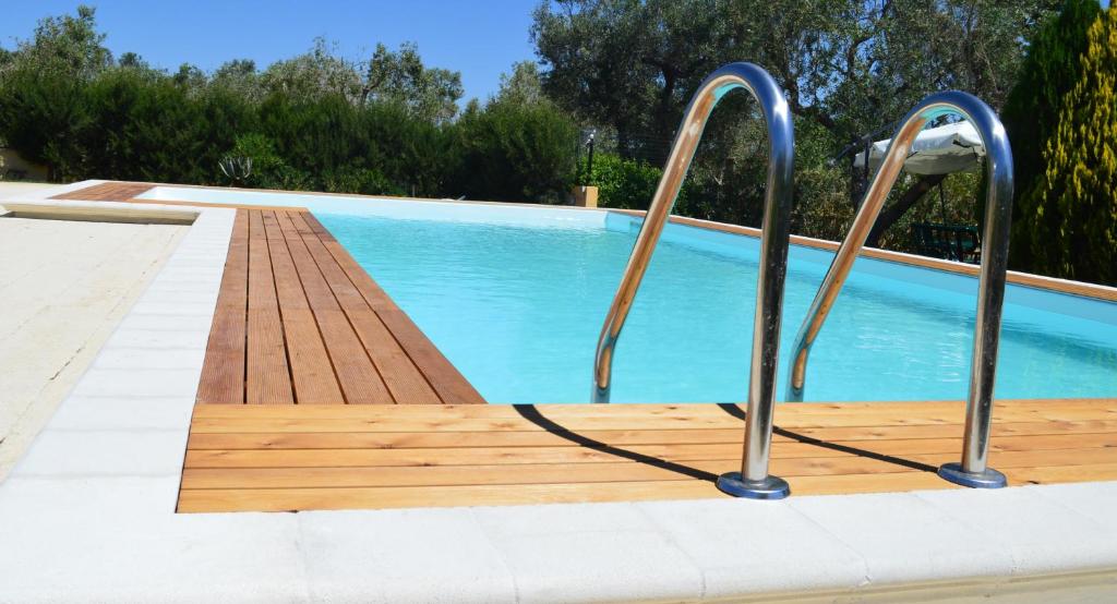 a swimming pool with two metal hand rails next to a pool at B&B Villaggio Regina in Matino
