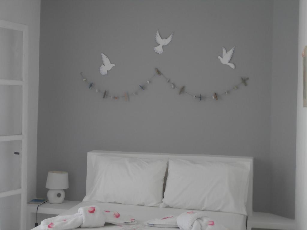 ティノス・タウンにあるAgali Apartmentsのベッドルーム1室(壁に鳥が描かれたベッド1台付)