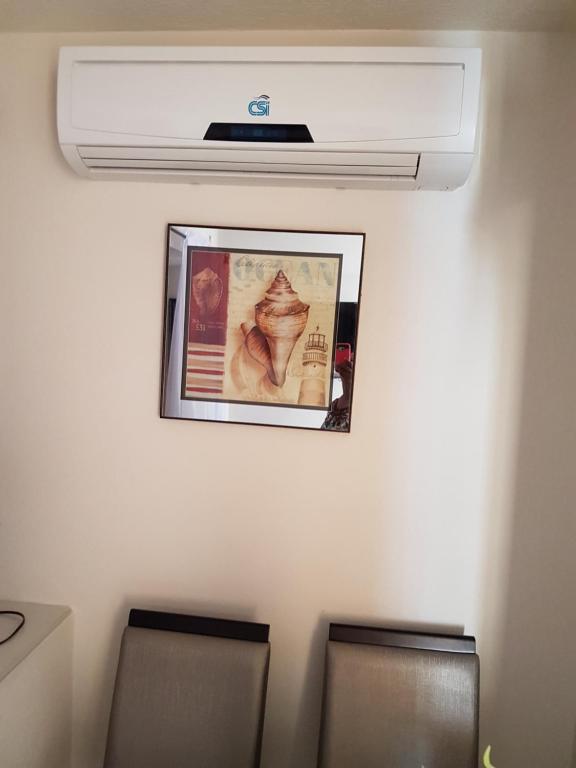 a room with two chairs and a ceiling fan at Glynver Apartments in Christ Church