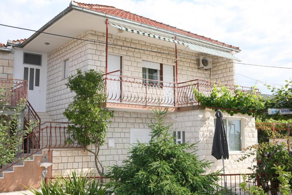 a white brick house with a pink balcony at Apartment Nives in Trogir