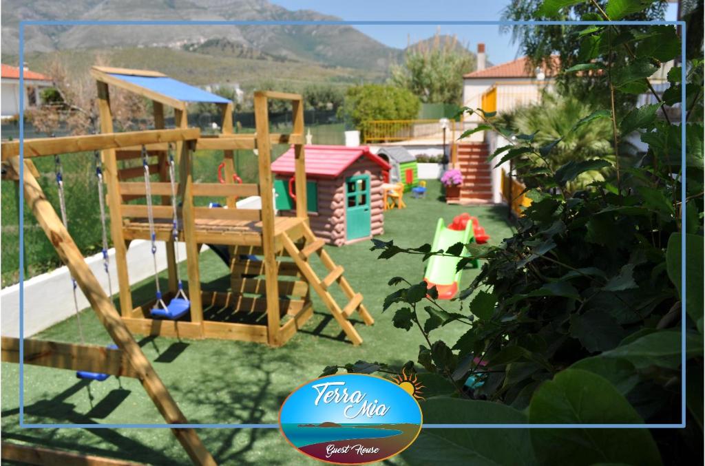 un patio trasero con parque infantil y una casa de juegos en Terra Mia, en Formia