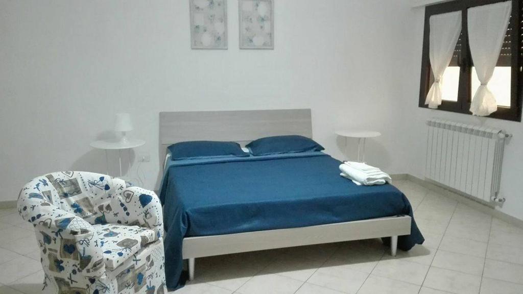 マンドゥーリアにあるAmareViaggiareLowcostのベッドルーム1室(ベッド1台、椅子付)