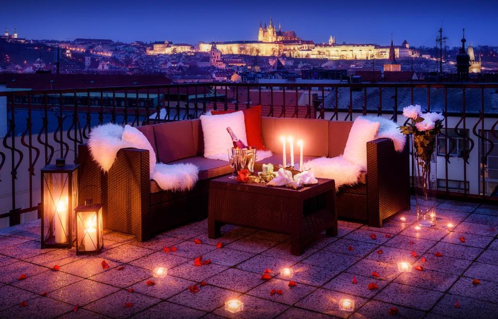 un patio en la azotea con sofás y una mesa con velas en A/C + TERRACE Breakfast at Tiffany’s, en Praga