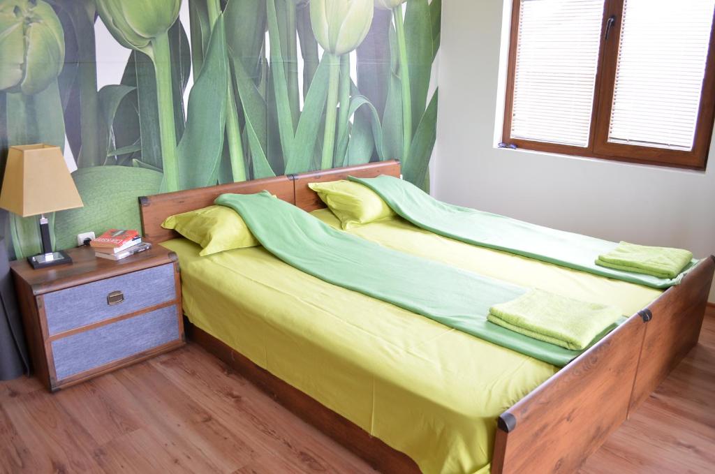 ポモリエにあるART Apartments - Pomorieのベッドルーム1室(黄色と緑のシーツが敷かれたベッド1台付)