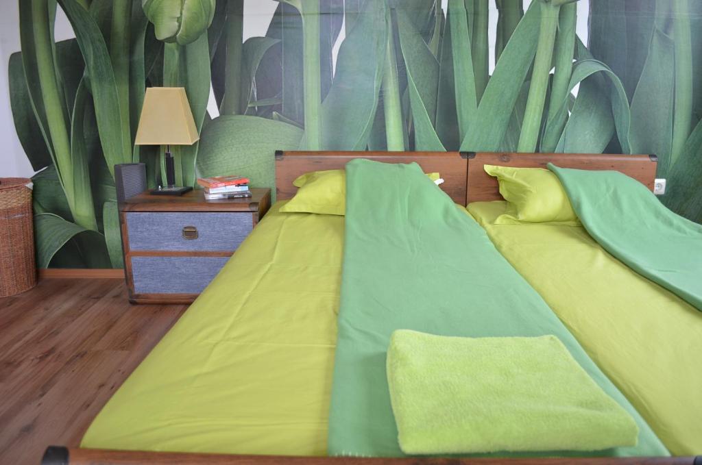 a bedroom with a bed with yellow and green sheets at ART Apartments - Pomorie in Pomorie