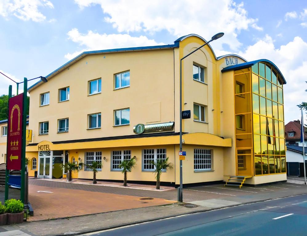 ein gelbes Gebäude an der Straßenseite in der Unterkunft Bach Hotel in Porta Westfalica