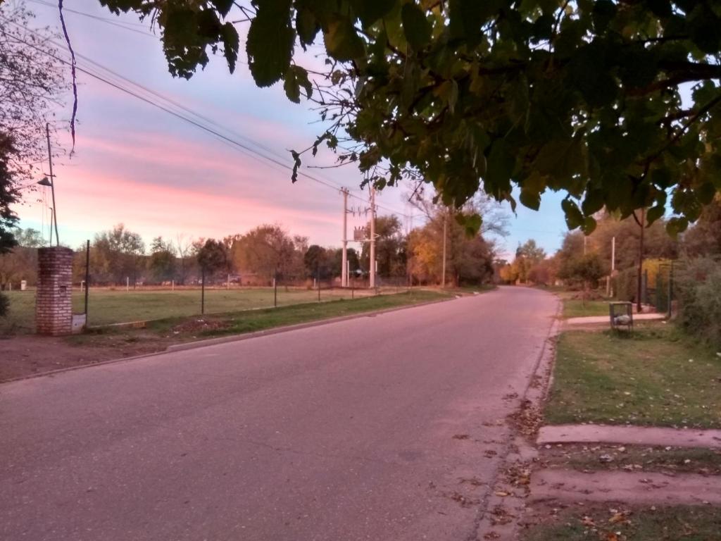 an empty road with a sunset in the background at Alojamiento Cuchi Corral in San Luis
