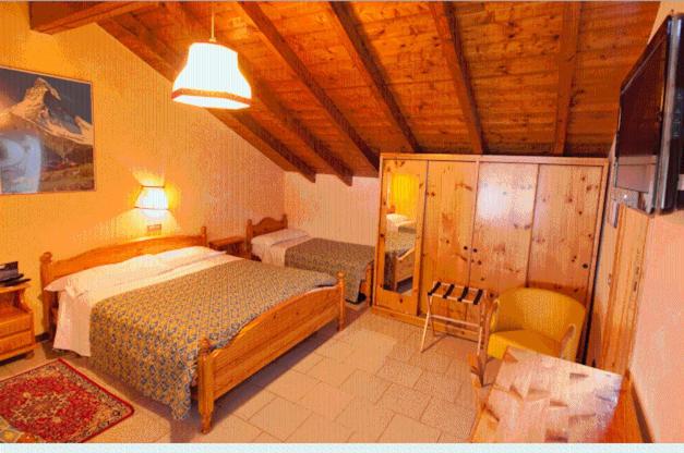 ein Schlafzimmer mit einem Bett und einem Stuhl in einem Zimmer in der Unterkunft Hotel Stelvio in Varese