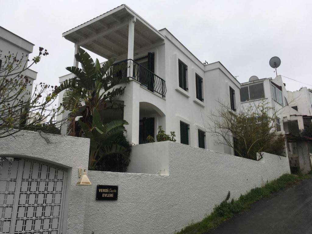 a white house with a balcony on top of it at Casita Verdi Evleri in Yalıkavak