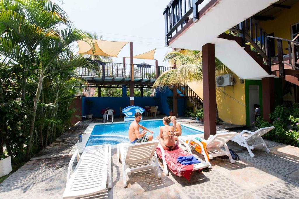 Dos personas sentadas en la piscina de un complejo en Papaya Lodge, en La Libertad