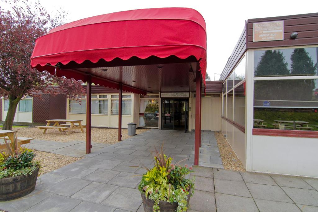 um edifício com um toldo vermelho fora dele em The Burnside Hotel em Glasgow