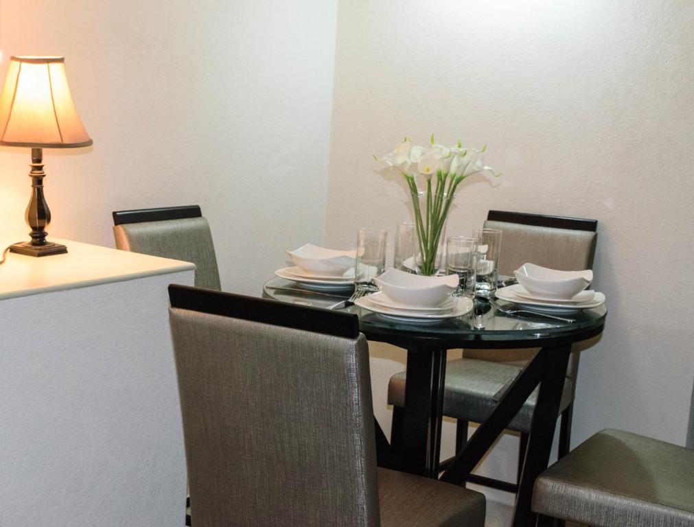 a dining room table with a vase of flowers on it at Glynver Apartments in Christ Church