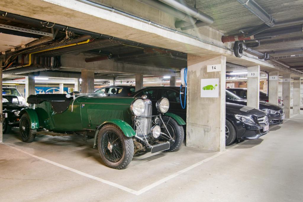 a green car parked in a garage with other cars at Dukes' Academie Brugge - by Dukes' Hotel Collection in Bruges
