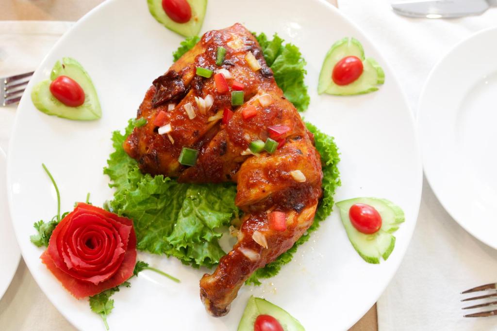 a plate of food with a piece of meat and salad at New Space Hotel Airport in Ho Chi Minh City