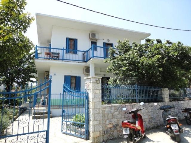 una casa con una moto aparcada frente a ella en Smile Stella Studios, en Skopelos Town