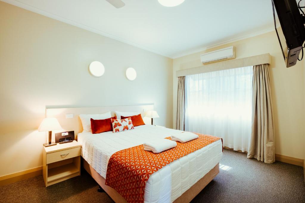 Un dormitorio con una cama grande y una ventana en Club Motor Inn, en Narrabri