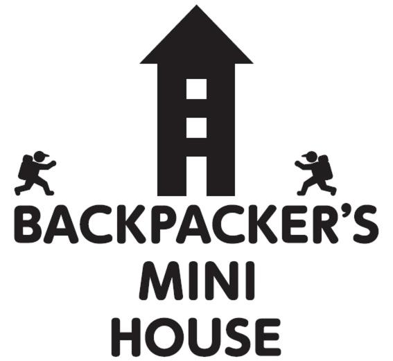 dos personas corriendo en la cima de una colina con el mensajero min house en Backpacker's Mini House, en Tokio