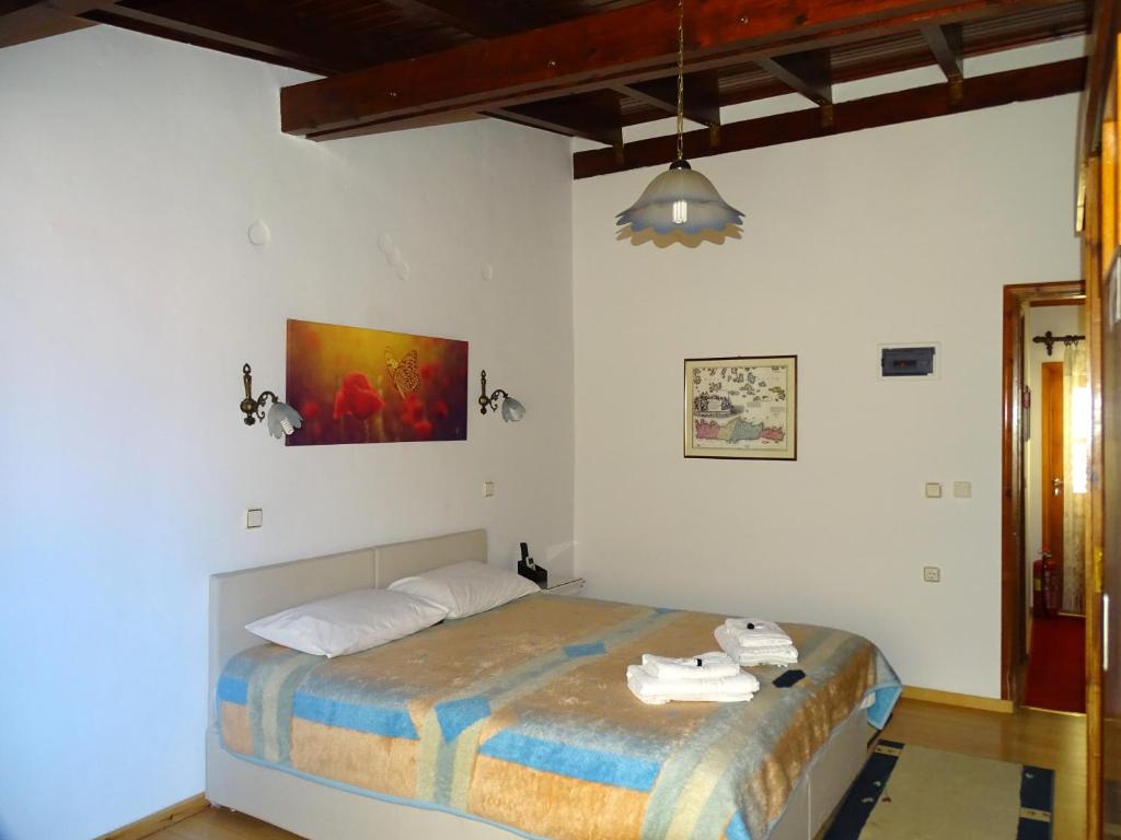 sypialnia z łóżkiem i obrazem na ścianie w obiekcie Anemones Rooms w Chanii