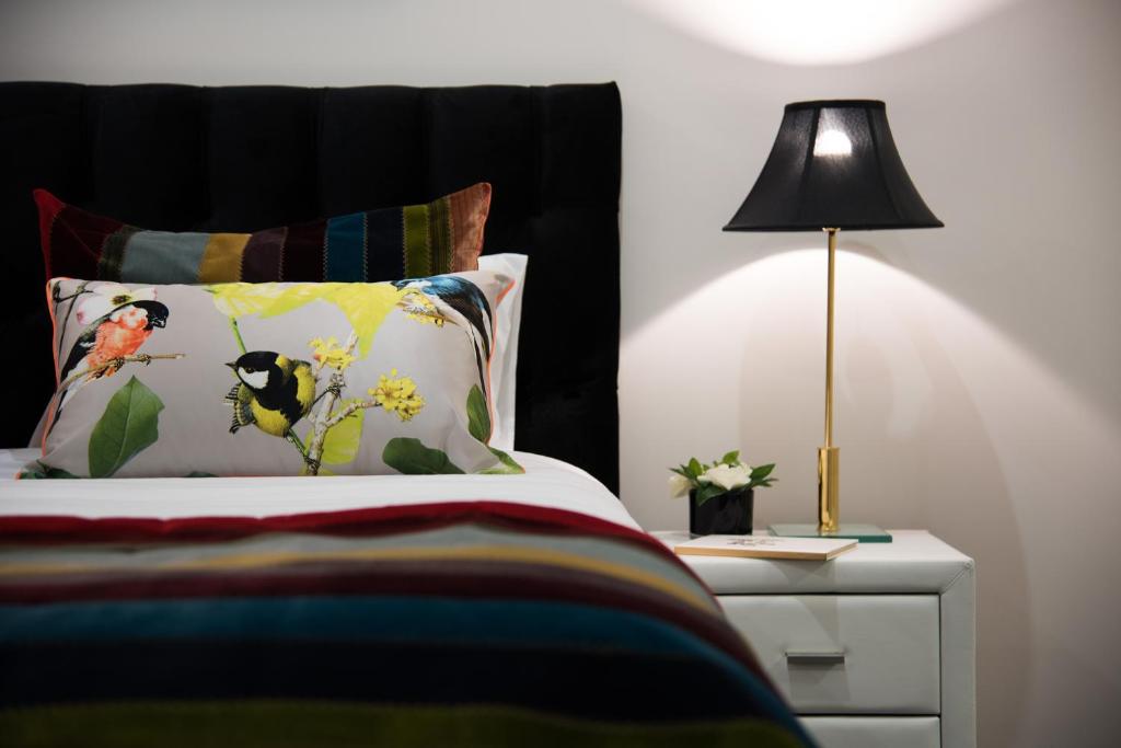 1 dormitorio con cama y mesita de noche con lámpara en Azura, en Daylesford