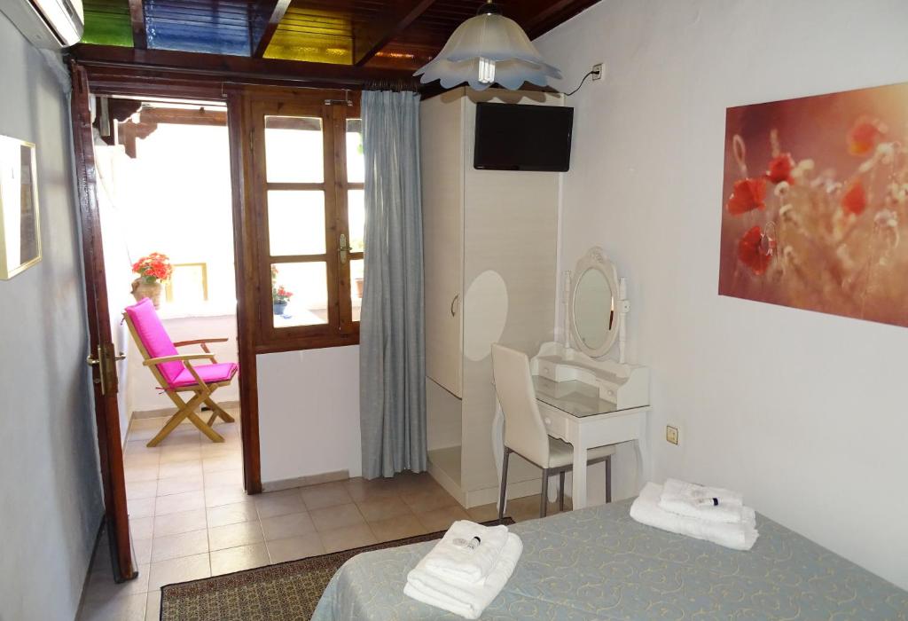 sypialnia z łóżkiem i biurkiem z lustrem w obiekcie Anemones Rooms w Chanii