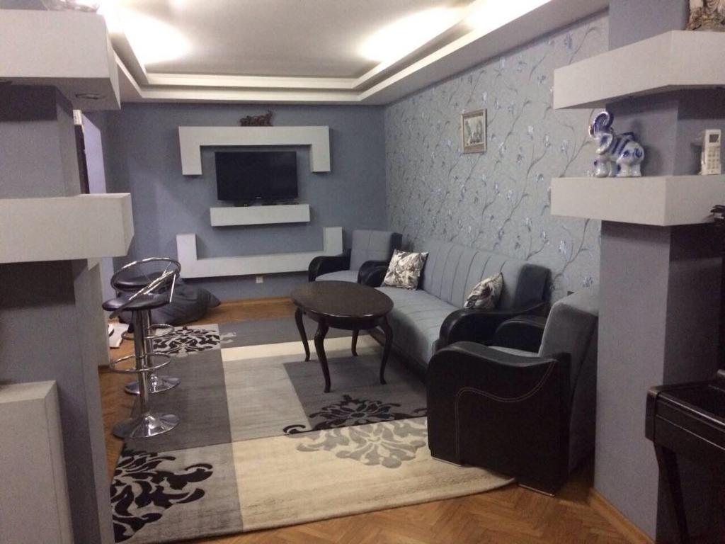 uma sala de estar com um sofá e uma televisão em Akaki's Apartment em Batumi