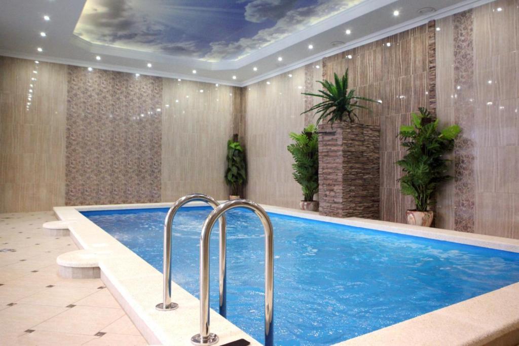 a large swimming pool in a room with a ceiling at Hotel Usadba in Georgiyevsk