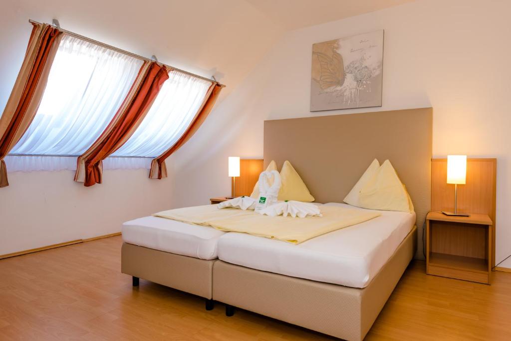 Postel nebo postele na pokoji v ubytování Stadthotel Schwerterbräu