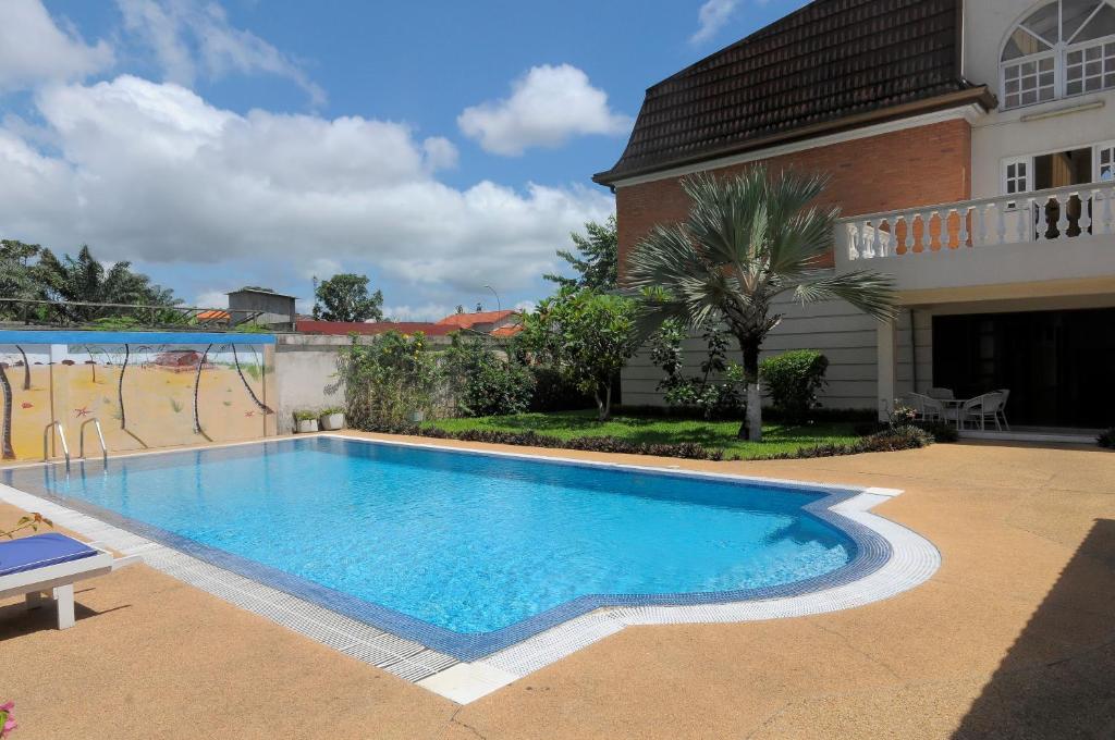 a swimming pool in front of a house at Residence Eburnea in Abidjan