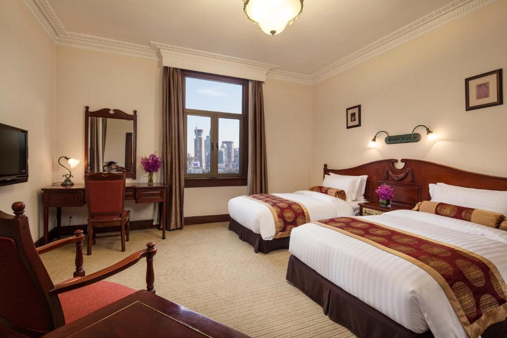 Postel nebo postele na pokoji v ubytování Jin Jiang Pacific Hotel