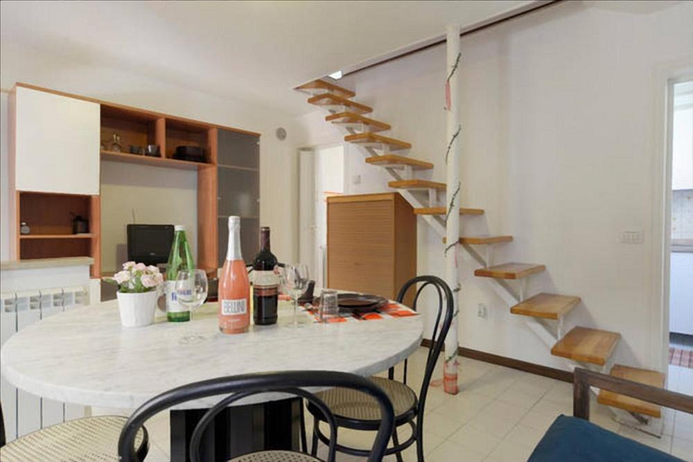 a room with a table with chairs and a staircase at 2578 casa in Venice