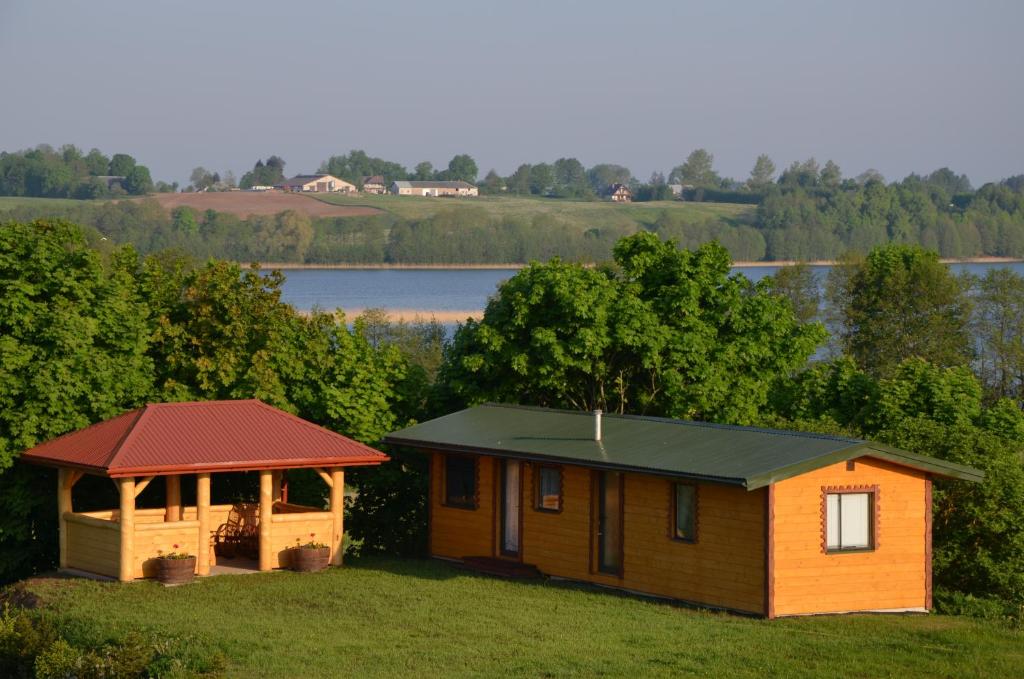 een klein huis met een tuinhuisje en een meer bij Domek nad jeziorem Gaładuś in Sejny
