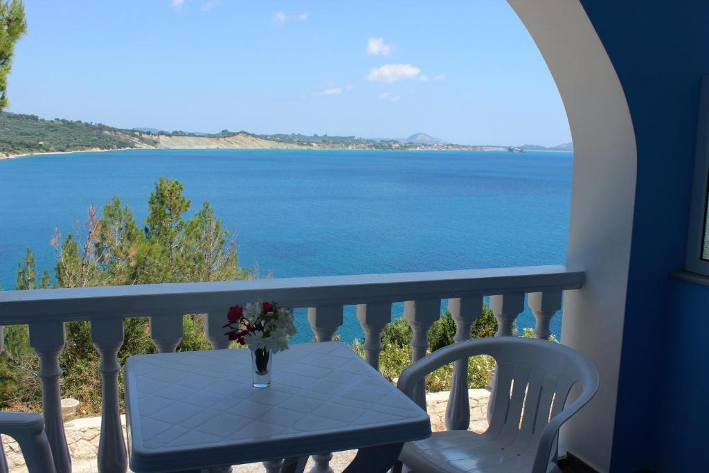 a table and chairs on a balcony with a view of the ocean at Villa Bella Vista in Marathias