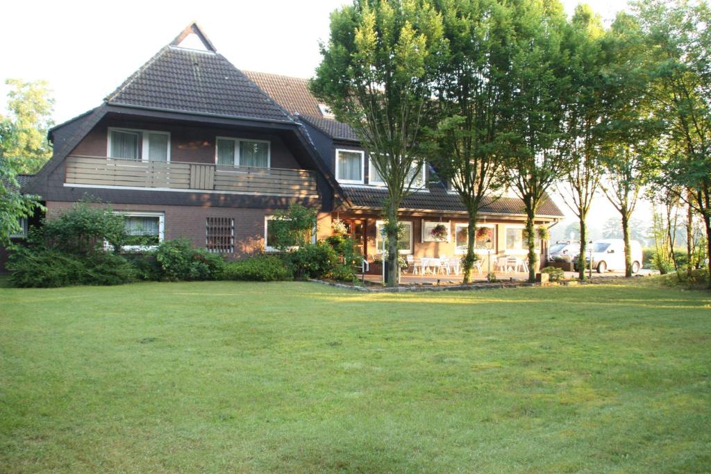 una casa grande con un gran patio delante en Landhaus Riedel en Papenburg