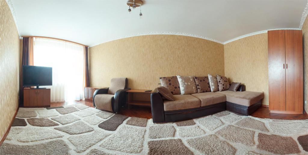 オムスクにあるOmsk Sutki Apartments on Marshala Zhukova 148aのリビングルーム(ソファ、テレビ付)