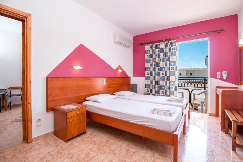 een slaapkamer met een groot bed met een rood hoofdeinde bij Mosaic Gardens in Faliraki