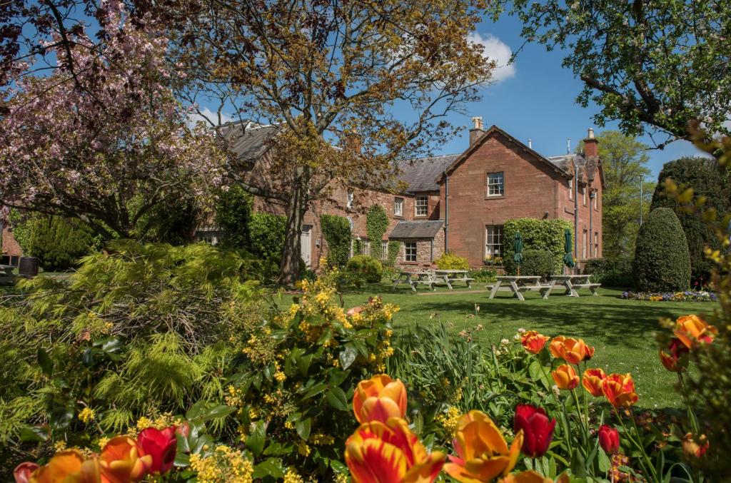 un jardín frente a una casa con flores en Buccleuch Arms, en Saint Boswells