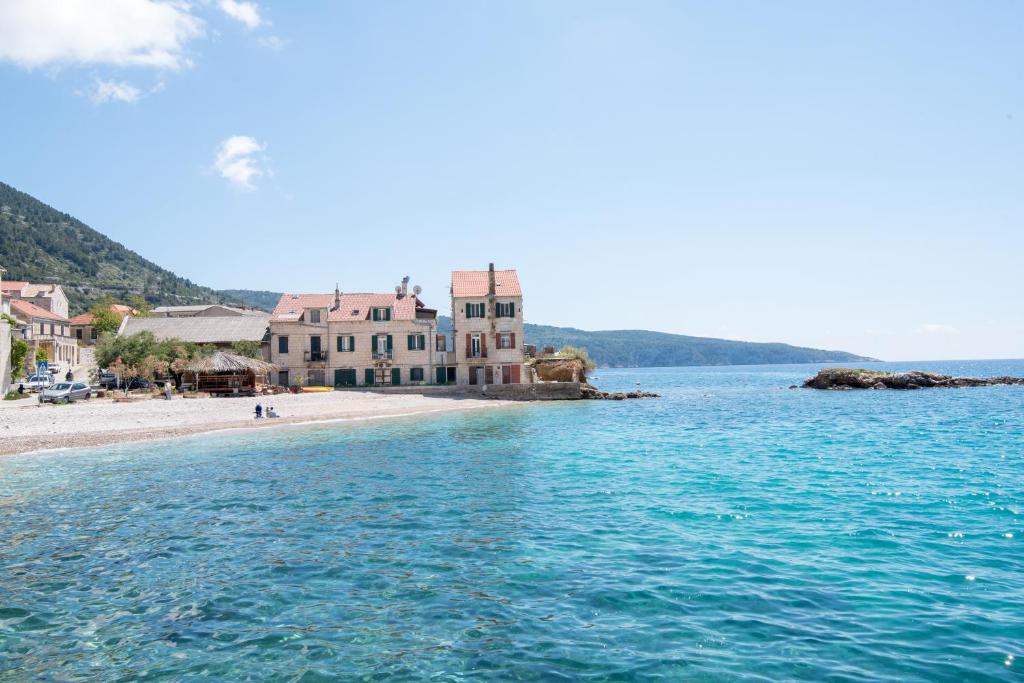 Blick auf einen Strand mit einem Haus im Wasser in der Unterkunft Apartments On the Beach in Komiža