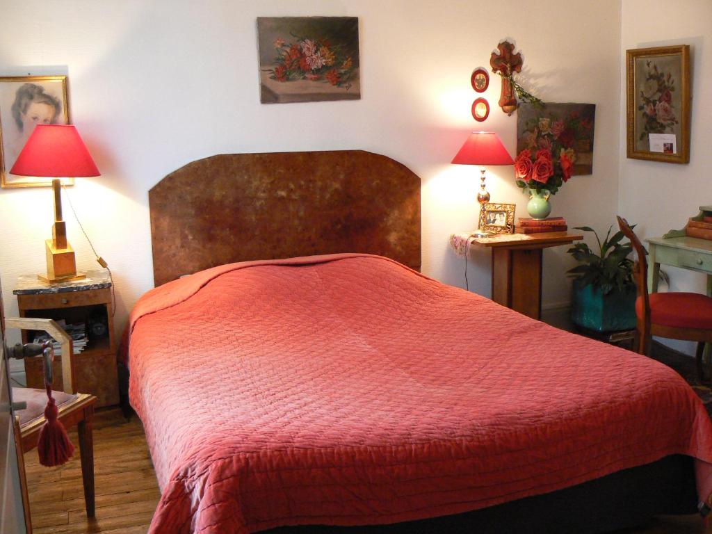 - une chambre avec un grand lit et une couverture rouge dans l'établissement Chambres d'hôtes la Graineterie, à Buxy