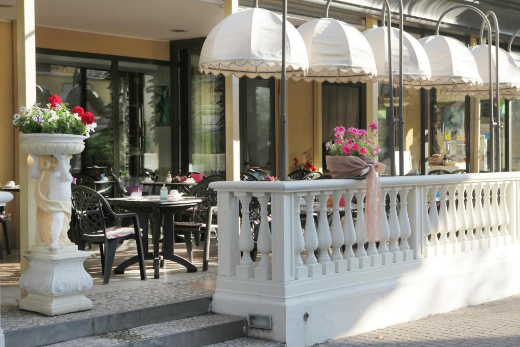 a white railing with flowers in a restaurant at Hotel La Nidiola in Riccione
