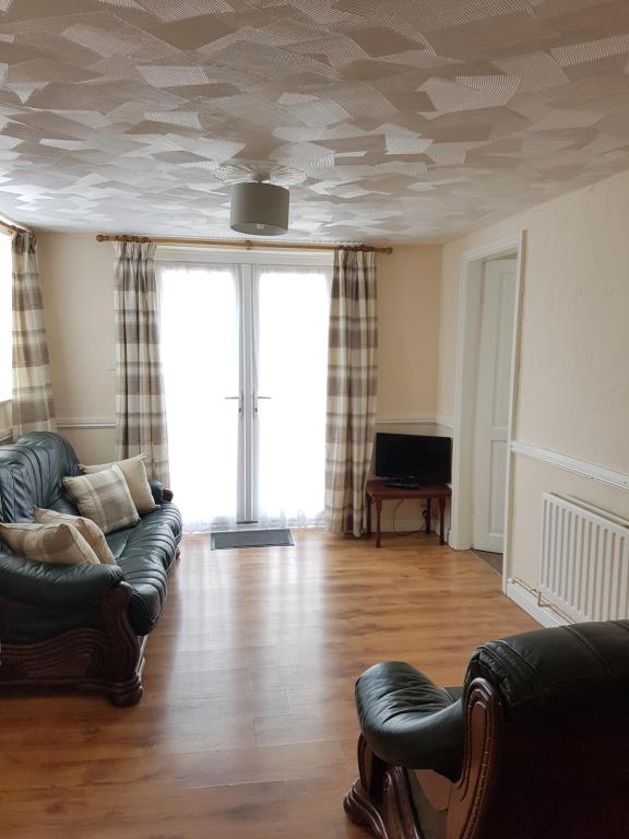 a living room with a couch and a tv at Holly Cottage in Burgh le Marsh