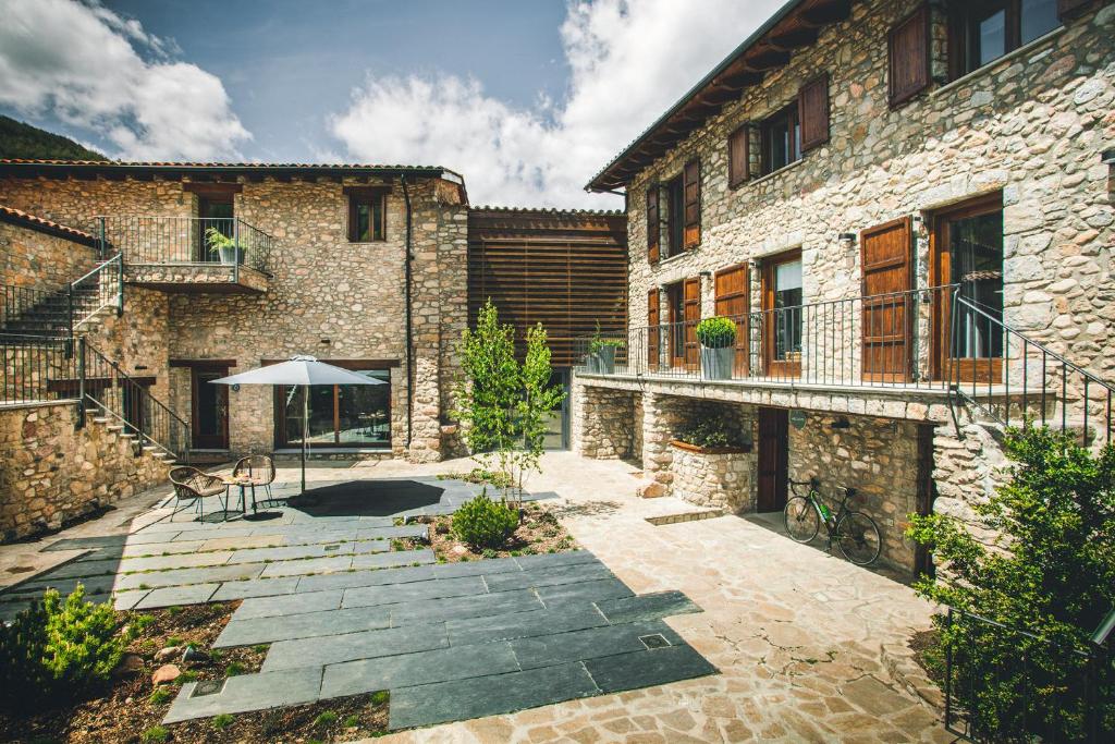 a courtyard of a stone building with an umbrella at Intrepid Hotel Rural - Adults Only in Pi