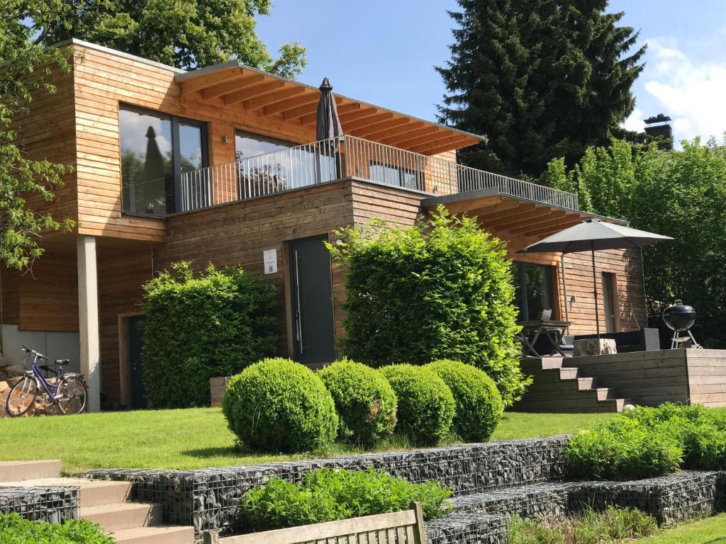 ein Haus mit Balkon und Rasen in der Unterkunft Ferienhaus Poppenhausen in Poppenhausen