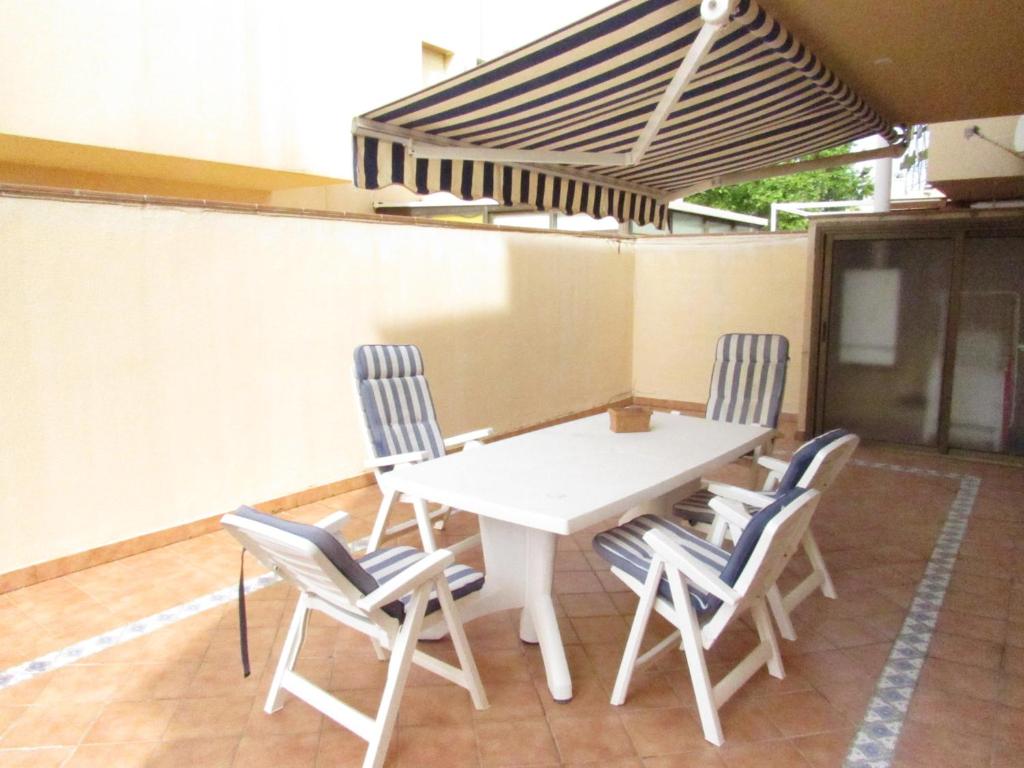 een witte tafel en stoelen op een patio bij Saromar I Apartament amb gran terrassa, per 6 persones a 5 minuts de la Platja Gran in Platja  d'Aro