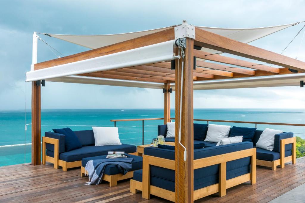 a deck with blue couches and a canopy at Bay Villas Koh Phangan in Salad Beach