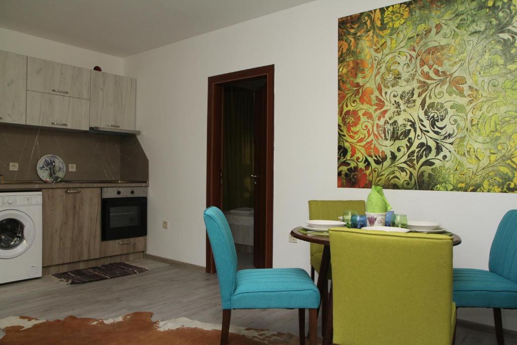 a kitchen with a table and chairs and a painting on the wall at Villa Salena in Primorsko