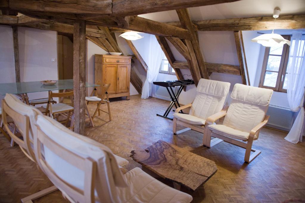 uma sala de estar com cadeiras brancas e uma mesa em Le Cep en Sancerrois em Sancerre