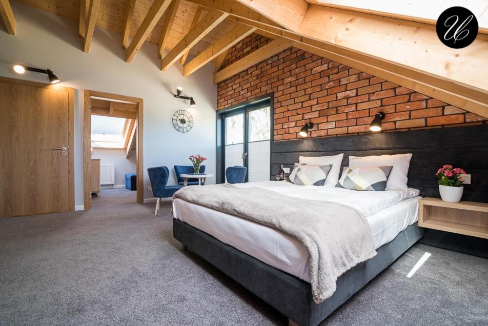a bedroom with a large bed and a brick wall at U przyjaciol - Debki in Dębki