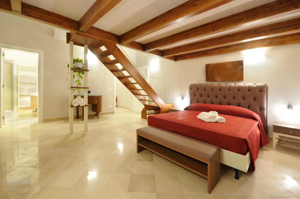 a bedroom with a red bed and a staircase at Palazzo Massari in Lecce